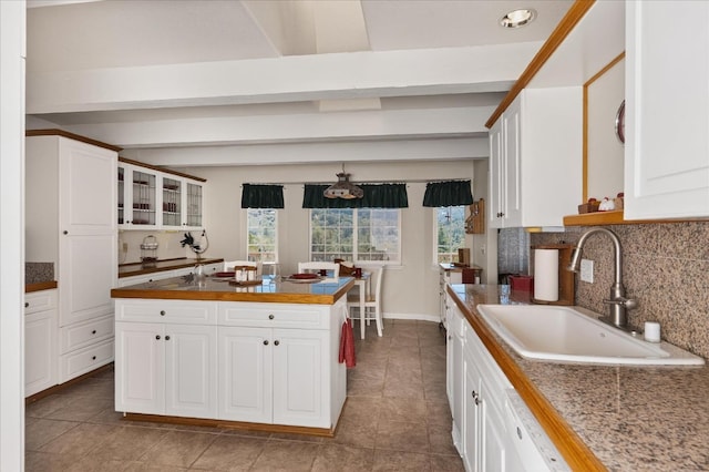 39397 Moonray Ln, Oakhurst, CA 93644 - kitchen featuring tasteful backsplash, white cabinets, a kitchen island, and tile patterned flooring