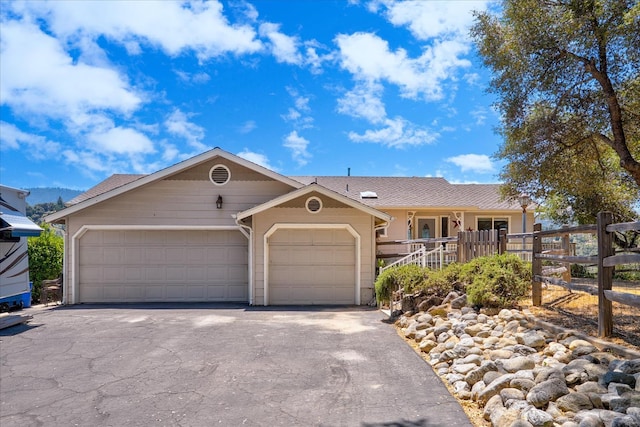 39397 Moonray Ln, Oakhurst, CA 93644 - ranch-style house with an attached garage, asphalt driveway, roof with shingles, and a porch