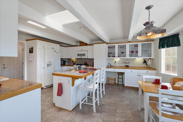 39397 Moonray Ln, Oakhurst, CA 93644 - kitchen featuring white appliances, white cabinetry, glass insert cabinets, a breakfast bar area, and beamed ceiling