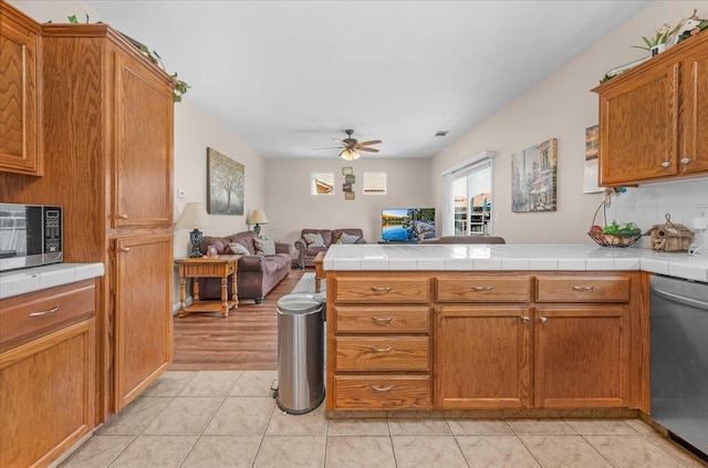 6164 W Keats, Fresno, CA 93723 - kitchen featuring open floor plan, stainless steel appliances, ceiling fan, a peninsula, and brown cabinetry