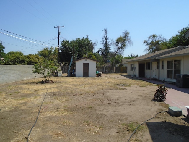 935 S Park Circle Dr, Fresno, CA 93727 - fenced backyard featuring a storage unit and a patio area