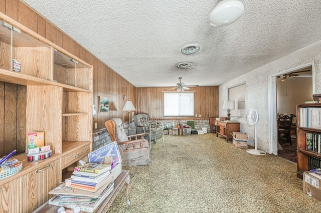 25 W Dinuba Ave, Fresno, CA 93706 - living area with a ceiling fan, a textured ceiling, carpet floors, and wood walls