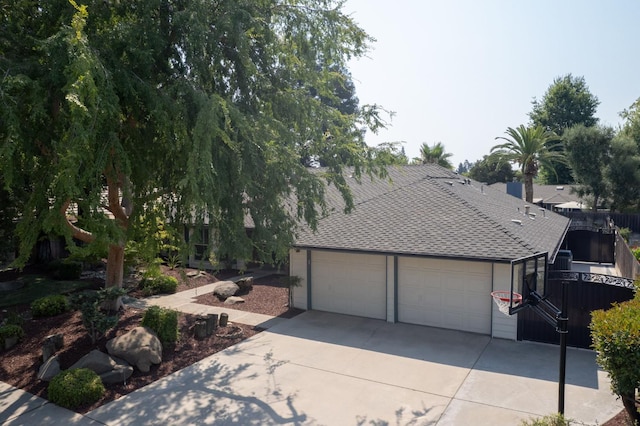 591 E Warwick Ave, Fresno, CA 93720 - obstructed view of property featuring a shingled roof, an attached garage, and driveway
