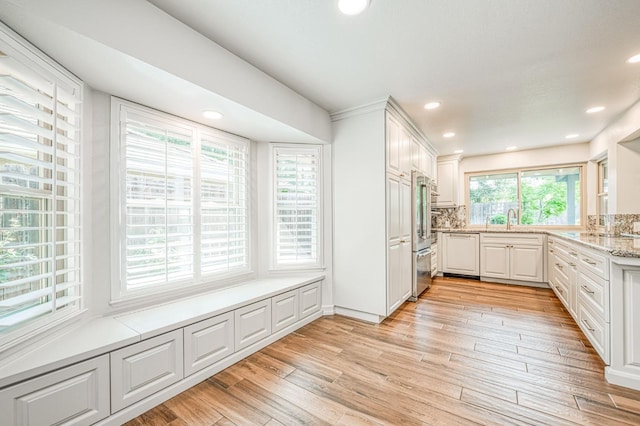 591 E Warwick Ave, Fresno, CA 93720 - kitchen with light wood-style flooring, white cabinetry, light stone counters, backsplash, and high end refrigerator