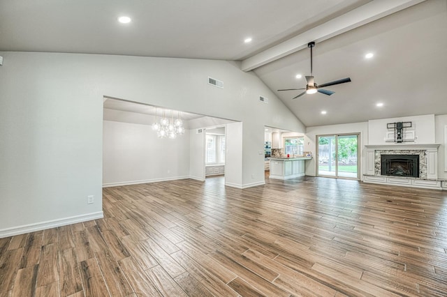 591 E Warwick Ave, Fresno, CA 93720 - unfurnished living room with a ceiling fan, beamed ceiling, wood finished floors, a chandelier, and a fireplace with raised hearth