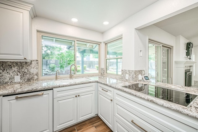 591 E Warwick Ave, Fresno, CA 93720 - kitchen with black electric cooktop, light wood-type flooring, white cabinets, backsplash, and light stone countertops