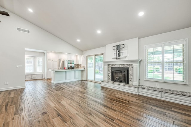 591 E Warwick Ave, Fresno, CA 93720 - unfurnished living room with wood finished floors, a fireplace with raised hearth, high vaulted ceiling, and recessed lighting