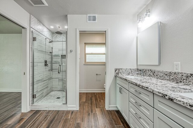 591 E Warwick Ave, Fresno, CA 93720 - bathroom with a stall shower, vanity, and wood finished floors