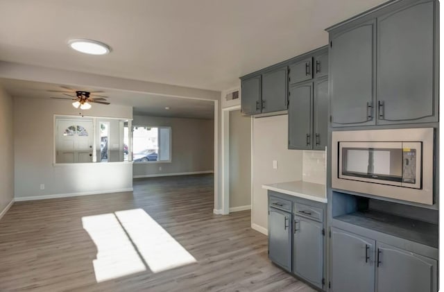 6236 N Bond St, Fresno, CA 93710 - kitchen featuring light wood-style floors, gray cabinets, a ceiling fan, stainless steel microwave, and light countertops