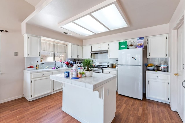 539 Chablis Ave, Madera, CA 93637 - kitchen with tile counters, freestanding refrigerator, white cabinets, decorative backsplash, and wood finished floors