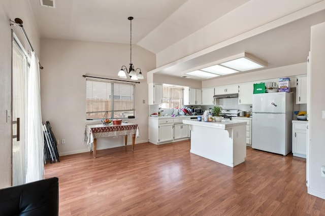 539 Chablis Ave, Madera, CA 93637 - kitchen featuring freestanding refrigerator, light countertops, lofted ceiling, a chandelier, and a kitchen island
