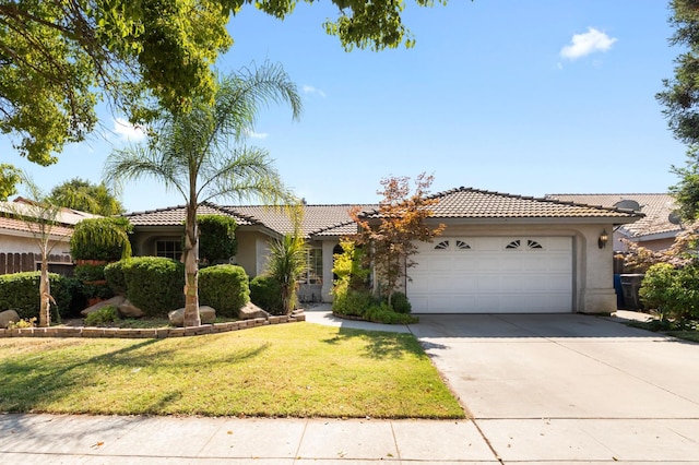 539 Chablis Ave, Madera, CA 93637 - view of front of house with stucco siding, a tile roof, driveway, a garage, and a front yard