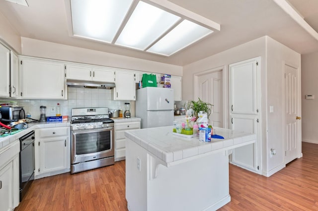 539 Chablis Ave, Madera, CA 93637 - kitchen featuring tile countertops, appliances with stainless steel finishes, white cabinetry, and light wood-style flooring