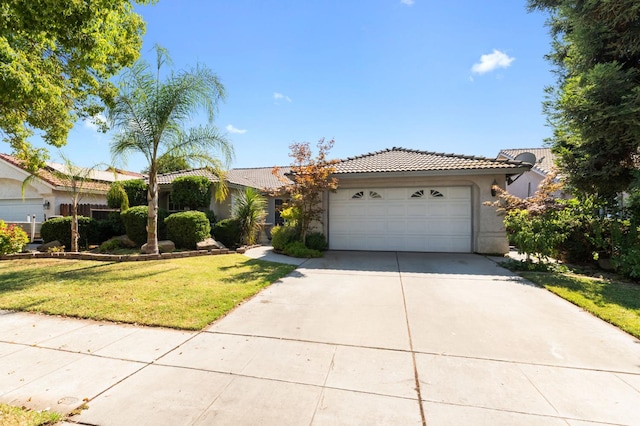 539 Chablis Ave, Madera, CA 93637 - view of front facade featuring a tile roof, a garage, driveway, stucco siding, and a front lawn