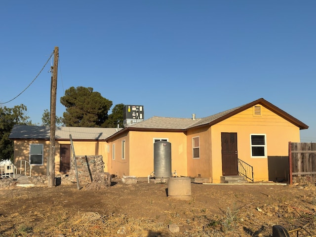 1741 N Blythe Ave, Fresno, CA 93722 - back of property with entry steps, crawl space, and roof with shingles