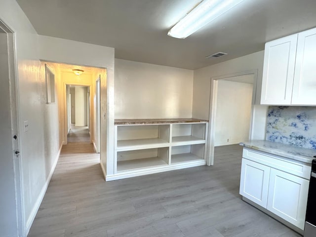 1741 N Blythe Ave, Fresno, CA 93722 - kitchen with white cabinetry, light wood-style flooring, light stone counters, and range with gas cooktop