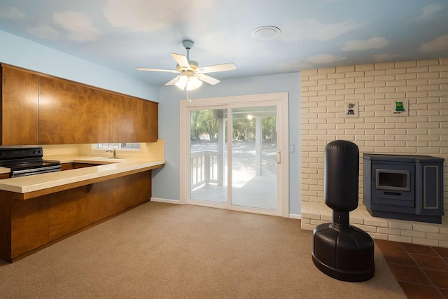 31736 Apache Rd, Coarsegold, CA 93614 - kitchen with black / electric stove, brown cabinets, a ceiling fan, a breakfast bar area, and a peninsula