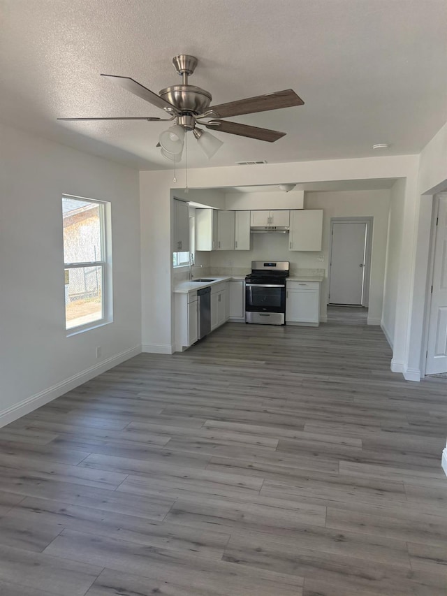 3852 E Thomas Ave, Fresno, CA 93702 - kitchen with appliances with stainless steel finishes, light countertops, ceiling fan, wood finished floors, and a textured ceiling