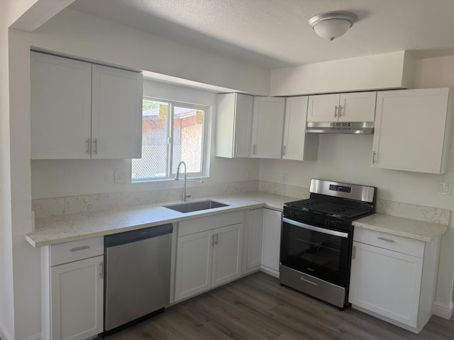 3852 E Thomas Ave, Fresno, CA 93702 - kitchen with appliances with stainless steel finishes, wood finished floors, white cabinetry, under cabinet range hood, and a textured ceiling