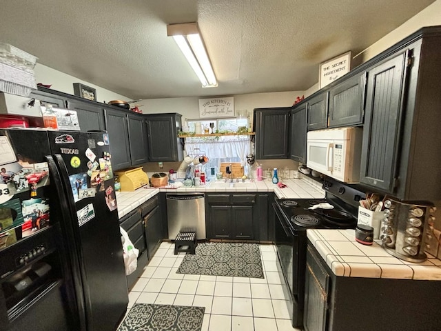 3315 Dewey Ave, Fresno, CA 93722 - kitchen with tile countertops, black appliances, a textured ceiling, and light tile patterned flooring
