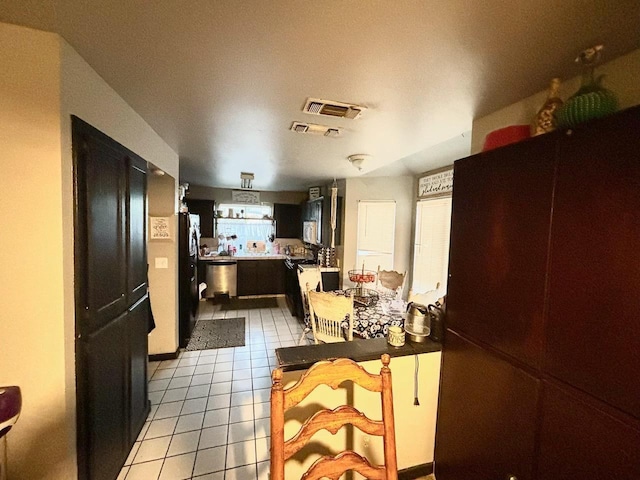 3315 Dewey Ave, Fresno, CA 93722 - kitchen featuring light tile patterned floors, freestanding refrigerator, range, stainless steel dishwasher, and light countertops