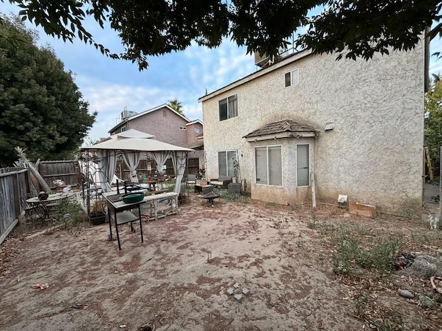 3315 Dewey Ave, Fresno, CA 93722 - rear view of house featuring a gazebo, stucco siding, a fenced backyard, a patio, and an outdoor fire pit