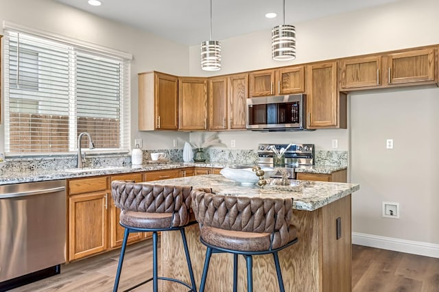 2234 E Serena Ave, Fresno, CA 93720 - kitchen featuring stainless steel appliances, wood finished floors, light stone counters, and recessed lighting