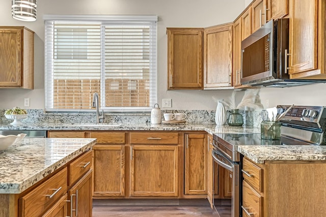 2234 E Serena Ave, Fresno, CA 93720 - kitchen featuring appliances with stainless steel finishes, wood finished floors, light stone counters, and brown cabinets