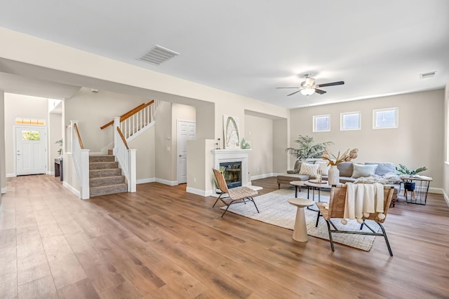 2234 E Serena Ave, Fresno, CA 93720 - living room featuring stairway, a ceiling fan, light wood-style floors, and a glass covered fireplace