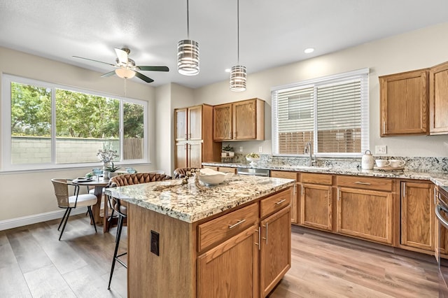 2234 E Serena Ave, Fresno, CA 93720 - kitchen featuring ceiling fan, light wood-style flooring, a kitchen island, light stone countertops, and recessed lighting