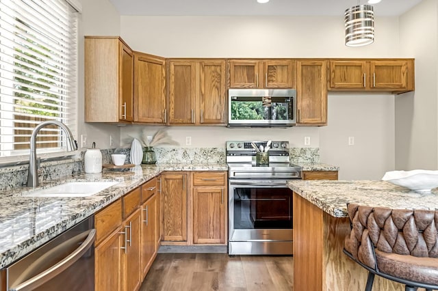2234 E Serena Ave, Fresno, CA 93720 - kitchen featuring appliances with stainless steel finishes, light stone counters, brown cabinets, and wood finished floors