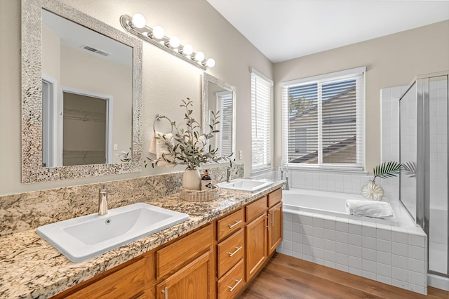 2234 E Serena Ave, Fresno, CA 93720 - full bathroom featuring wood finished floors, double vanity, a bath, a tile shower, and a spacious closet