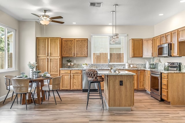 2234 E Serena Ave, Fresno, CA 93720 - kitchen with stainless steel appliances, recessed lighting, ceiling fan, light stone counters, and a center island