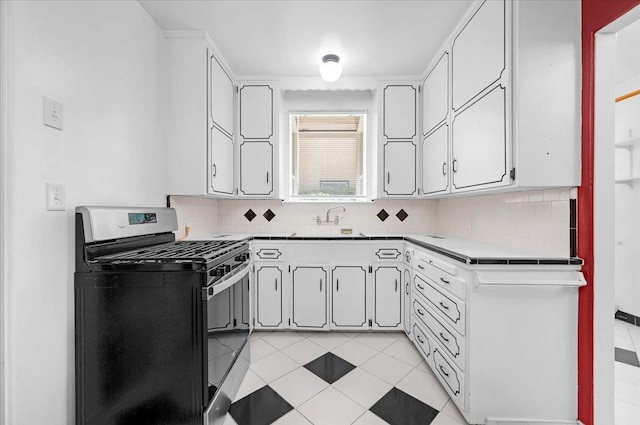 1461 N Harrison Ave, Fresno, CA 93728 - kitchen featuring stainless steel range with gas cooktop, tasteful backsplash, white cabinets, light tile patterned floors, and light countertops