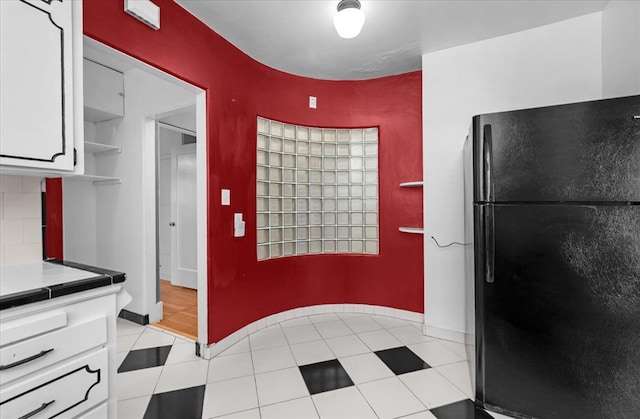 1461 N Harrison Ave, Fresno, CA 93728 - kitchen with freestanding refrigerator, white cabinets, open shelves, and light tile patterned floors