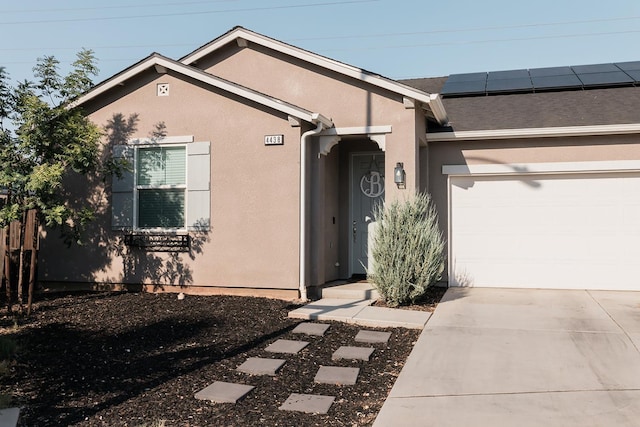 4438 N Sandrini Ave, Fresno, CA 93723 - view of front of property featuring a garage, concrete driveway, solar panels, and stucco siding