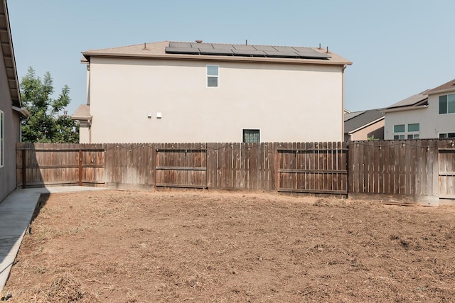 4438 N Sandrini Ave, Fresno, CA 93723 - back of property featuring stucco siding, solar panels, and a fenced backyard