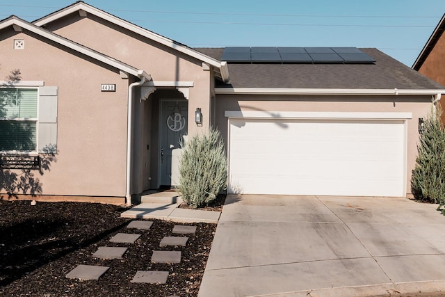 4438 N Sandrini Ave, Fresno, CA 93723 - ranch-style house featuring a garage, concrete driveway, solar panels, and stucco siding