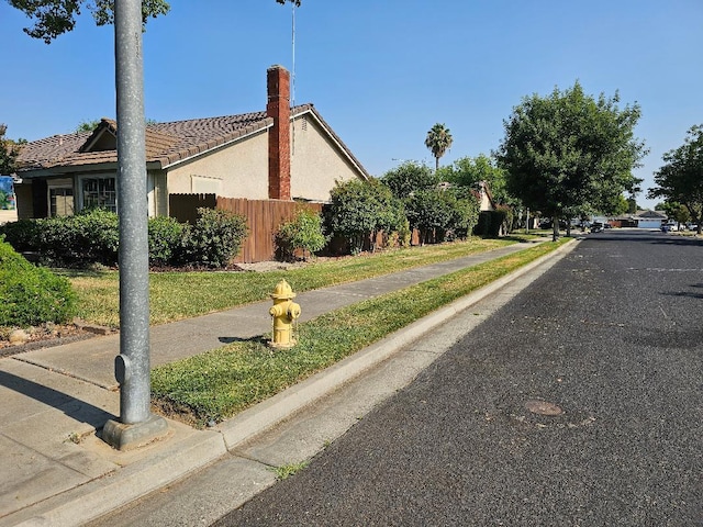 1509 Princeton Ave, Madera, CA 93637 - view of side of property featuring a tile roof, a chimney, and stucco siding