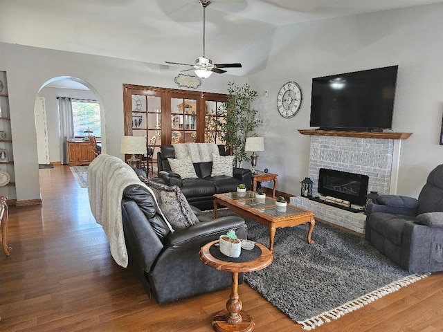 1509 Princeton Ave, Madera, CA 93637 - living room featuring arched walkways, wood finished floors, vaulted ceiling, a ceiling fan, and a fireplace
