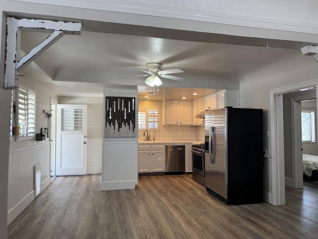 4741 W Mckinley Ave, Fresno, CA 93722 - kitchen with stainless steel appliances, dark wood finished floors, white cabinets, ceiling fan, and wainscoting
