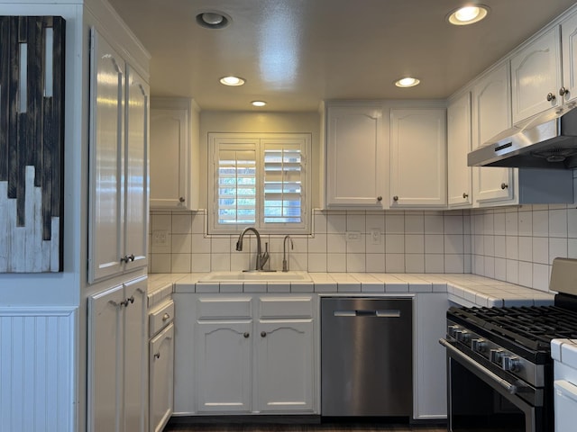4741 W Mckinley Ave, Fresno, CA 93722 - kitchen featuring stainless steel appliances, tile counters, white cabinets, recessed lighting, and tasteful backsplash