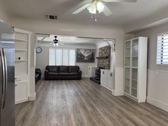 4741 W Mckinley Ave, Fresno, CA 93722 - living room with a ceiling fan, wood finished floors, and a wood stove