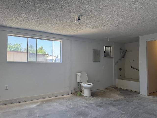 4741 W Mckinley Ave, Fresno, CA 93722 - bathroom with a textured ceiling, concrete flooring,  shower combination, and electric panel