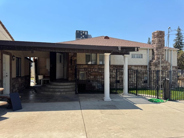4741 W Mckinley Ave, Fresno, CA 93722 - view of front facade featuring stone siding, roof with shingles, a chimney, and stucco siding