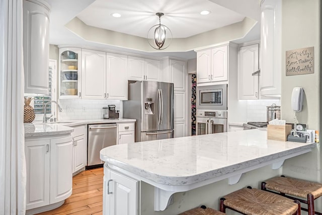 6609 N Dover Ct, Fresno, CA 93711 - kitchen featuring a peninsula, a kitchen breakfast bar, white cabinetry, appliances with stainless steel finishes, and recessed lighting