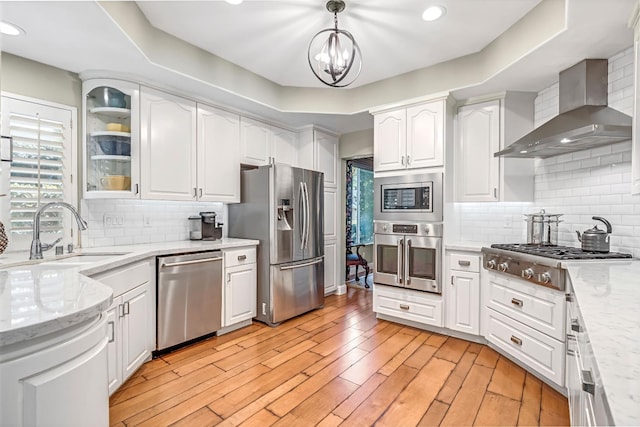 6609 N Dover Ct, Fresno, CA 93711 - kitchen featuring wall chimney exhaust hood, stainless steel appliances, white cabinetry, glass insert cabinets, and light stone countertops