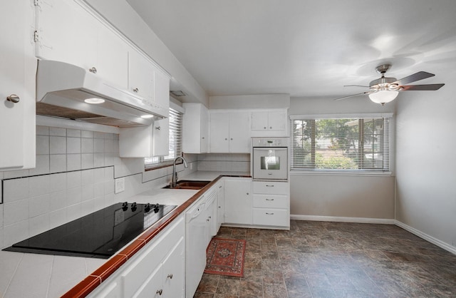 1556 E Loftus Ln, Fresno, CA 93710 - kitchen featuring under cabinet range hood, healthy amount of natural light, stone finish floors, and white appliances