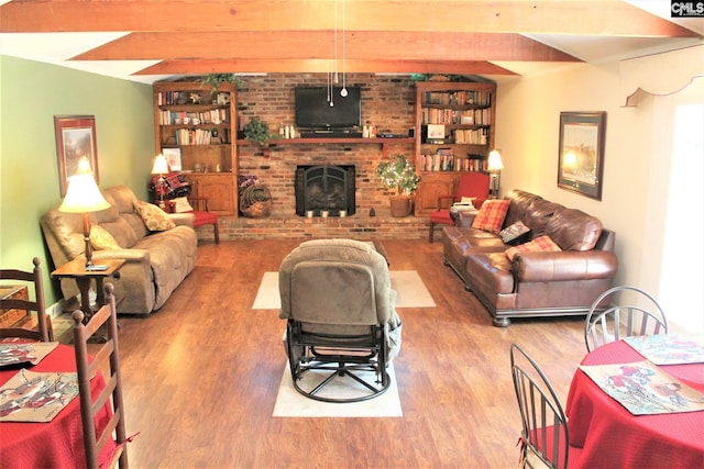 living room with brick wall, light hardwood / wood-style floors, vaulted ceiling with beams, and a brick fireplace