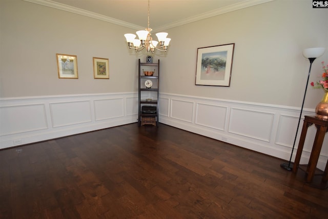 empty room with a chandelier, dark hardwood / wood-style floors, and crown molding